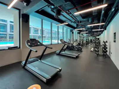 a gym with several treadmills and cardio machines at Signature Livings - Bright Studio in JVC in Dubai