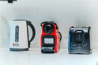 three appliances sitting on a white counter top at Binghatti Emerald, Jumeirah Village Circle in Dubai