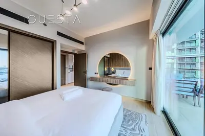 a bedroom with a white bed and a large window at Binghatti Emerald, Jumeirah Village Circle in Dubai