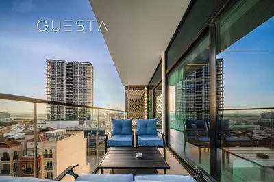 a balcony with blue chairs and a view of a city at Binghatti Emerald, Jumeirah Village Circle in Dubai
