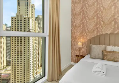 a bedroom with a bed and a large window at La Vie Beachside Elegance in Dubai