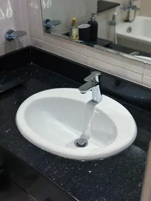 a white sink in a bathroom with a mirror at Stylish 2BR Retreat in JVC in Dubai
