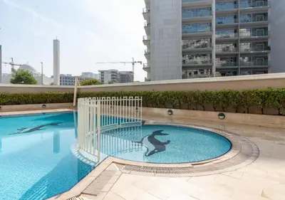 a swimming pool with a dolphin painted on the side of a building at Burj View - Luxury Studio - Near Dubai Miracle & Butterfly Garden- Arjan, Dubailand in Dubai