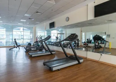 a gym with several treadmills and exercise bikes at Burj View - Luxury Studio - Near Dubai Miracle & Butterfly Garden- Arjan, Dubailand in Dubai