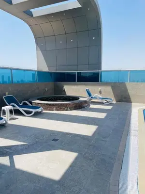 a building with chairs and a fire pit in front of it at Sport City with gym, pool, sauna in Dubai