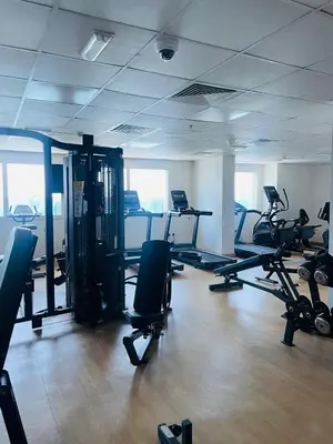 a gym with several treadmills and exercise bikes at Sport City with gym, pool, sauna in Dubai