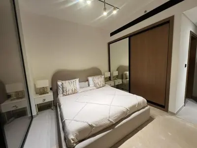 a bedroom with a bed and a large mirror at 1 Bedroom in Binghatti Lavender in Dubai