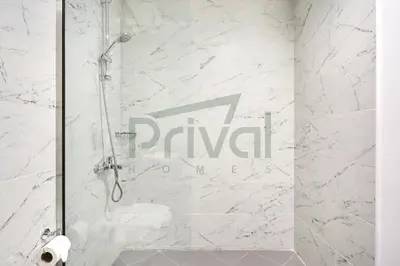 a shower with a glass door in a bathroom at Prival - Sunlit Serenity 1BR Retreat in Dubai