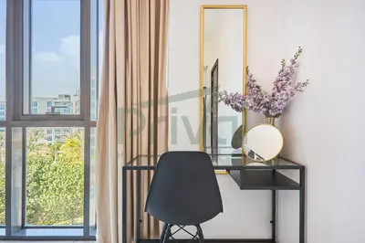 a desk with a mirror and a chair next to a window at Prival - Sunlit Serenity 1BR Retreat in Dubai