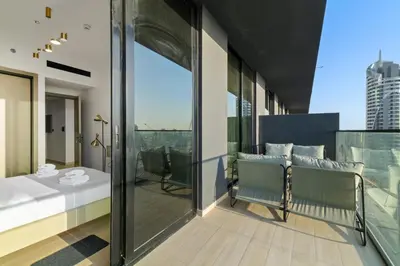 a room with a balcony with a table and chairs at Stylish 1BR w Skyline Views & Balcony in Dubai