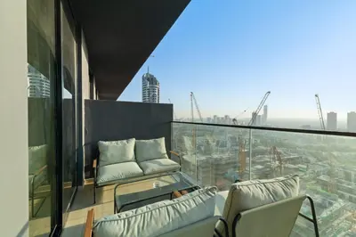 a balcony with chairs and a view of a city at Stylish 1BR w Skyline Views & Balcony in Dubai