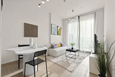 a white living room with a table and a couch at Stylish 1BR w Skyline Views & Balcony in Dubai