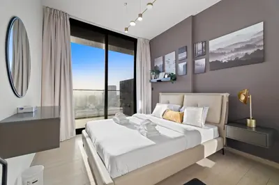 a bedroom with a large bed with a large window at Stylish 1BR w Skyline Views & Balcony in Dubai