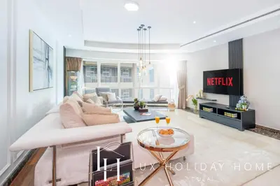 a living room with a couch and a tv at LUX The Al Seef Marina 4 bed Suite in Dubai