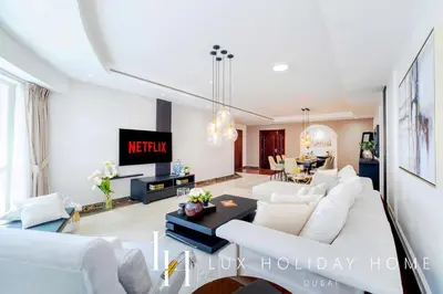 a living room with a white couch and a table at LUX The Al Seef Marina 4 bed Suite in Dubai