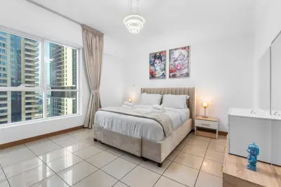 a bedroom with a bed and a large window at Stylish 1BR in Marina, Balcony Near JBR in Dubai