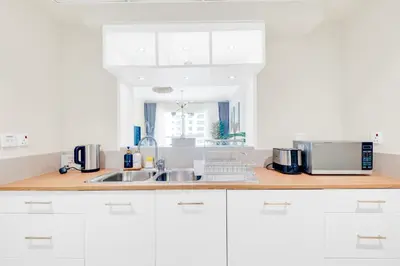 a kitchen with white cabinets and a sink at Dubai Marina Promenade 1BR Apartment with Pool near JBR in Dubai