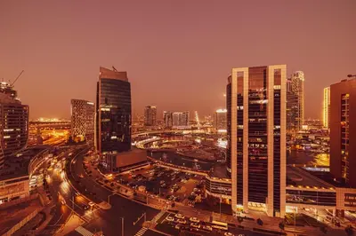 a city skyline at night with buildings and traffic at Cosy Studio, 7-min walk Burj Khalifa and Dubai Mall in Dubai