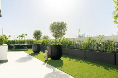 a garden with three black objects on the grass at CitiHome - Studio Azizi Riviera in Dubai