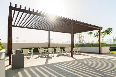 a pergola with tables and chairs on a patio at CitiHome - Studio Azizi Riviera in Dubai