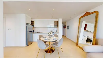 a dining room with a table and chairs and a mirror at Downtown Views 3 - Chic One Bed with City Views in Dubai