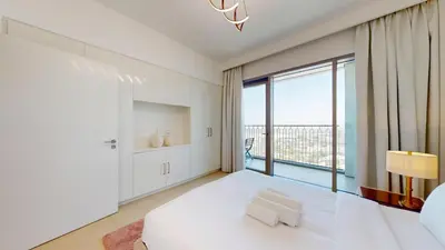 a bedroom with a white bed and a large window at Downtown Views 3 - Chic One Bed with City Views in Dubai