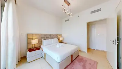 a bedroom with a white bed and a red rug at Downtown Views 3 - Chic One Bed with City Views in Dubai