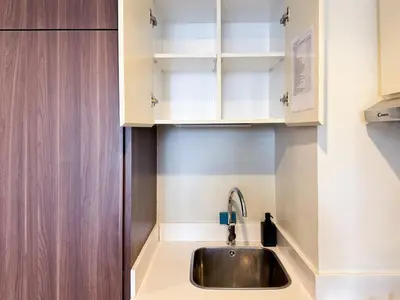a kitchen with a sink and white cabinets at Bronzite 2-Bed Apt Central Dubai Canal Views in Dubai