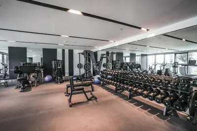 a gym with rows of exercise bikes and machines at QUARTZ Luxe 1-Bed at Nobles Tower, Near Downtown in Dubai