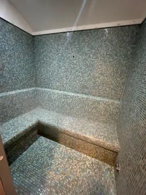a bathroom with a tub with tiles on the walls at Dubai Marina No 9 in Dubai