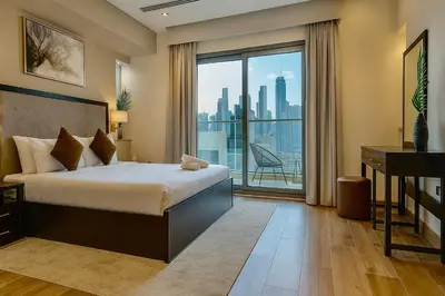 a hotel room with a bed and a large window at Premium 3BR Downtown Retreat with Pool & Iconic Burj Views in Dubai