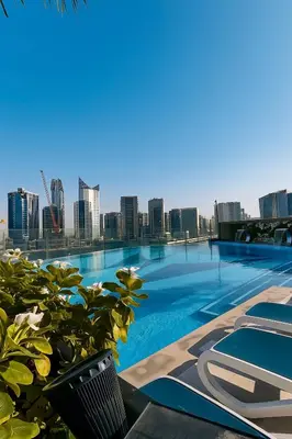 a swimming pool with a city skyline in the background at Premium 3BR Downtown Retreat with Pool & Iconic Burj Views in Dubai