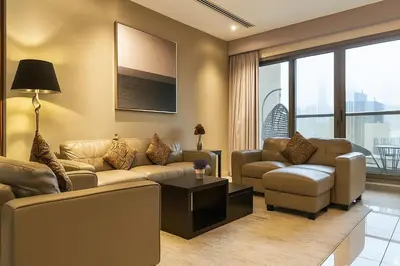 a living room with two couches and a table at Premium 3BR Downtown Retreat with Pool & Iconic Burj Views in Dubai