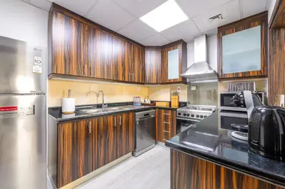 a kitchen with wooden cabinets and stainless steel appliances at Luxury JBR 2BR Shams Full Marina View Free 5 Star Beach Resorts Access in Dubai