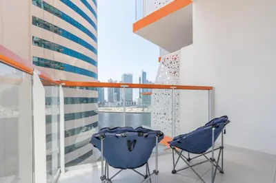 a balcony with two chairs and a view of the city at Luxurious apartment 8 mins from Burj Khalifa in Dubai