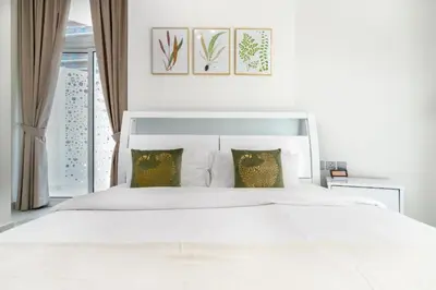 a white bedroom with a large white bed with pillows at Luxurious apartment 8 mins from Burj Khalifa in Dubai