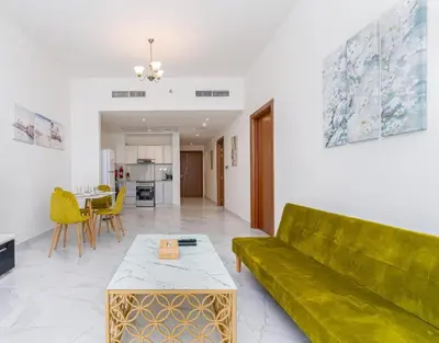 a living room with a green couch and a table at Luxurious apartment 8 mins from Burj Khalifa in Dubai