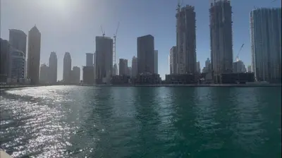 a body of water in front of a city with tall buildings at Luxurious apartment 8 mins from Burj Khalifa in Dubai