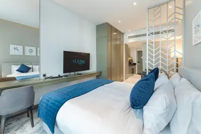 a bedroom with a large white bed with blue pillows at ALiving Luxury Studio with Balcony Views Prive 2007B in Dubai