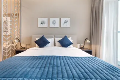 a bedroom with a blue and white bed with blue pillows at ALiving Luxury Studio with Balcony Views Prive 2007B in Dubai