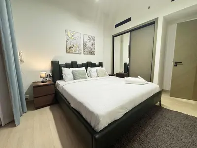 a bedroom with a large bed with white sheets at DVR 1BR Apartment Available in Binghatti Corner in Dubai
