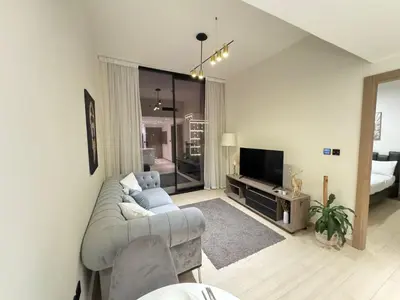 a living room with a couch and a television at DVR 1BR Apartment Available in Binghatti Corner in Dubai