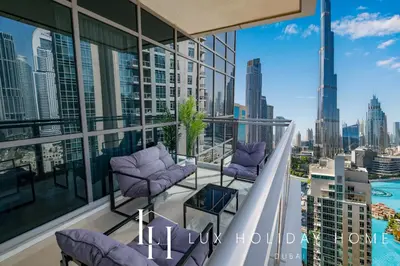 a balcony with purple chairs and a view of the city at LUX The Burj Khalifa Fountain View Suite 3 in Dubai