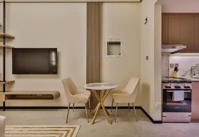 a kitchen with a table and chairs and a tv at Studio Apartment in Burj View Residence, Arjan - Allsopp & Allsopp in Dubai