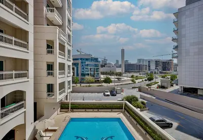 a view from the balcony of a building with a swimming pool at Studio Apartment in Burj View Residence, Arjan - Allsopp & Allsopp in Dubai