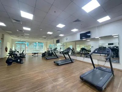 a gym with treadmills and ellipticals in a room at Studio Apartment in Burj View Residence, Arjan - Allsopp & Allsopp in Dubai
