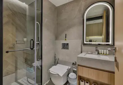 a bathroom with a shower and a toilet and a sink at Studio Apartment in Burj View Residence, Arjan - Allsopp & Allsopp in Dubai
