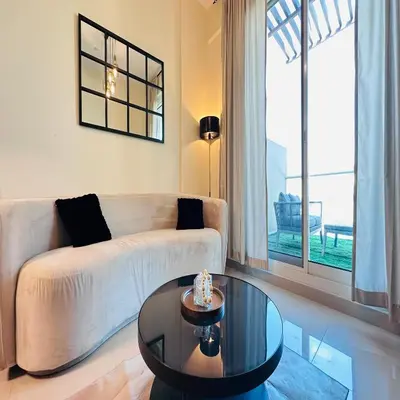 a living room with a couch and a table at Modern 1BR w Pool and Parking At Roxana Residence in Dubai