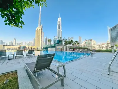 a patio with chairs and a table with a view of a city at Luxurious 1BR High Floor Skyline View Downtown in Dubai