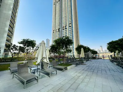 a courtyard with chairs and umbrellas in a city at Luxurious 1BR High Floor Skyline View Downtown in Dubai